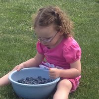 a young girl with a bowl of blueberries